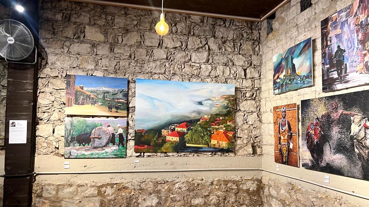 Sala de muros de piedra de Dar Saab Art Gallery con pinturas expuestas