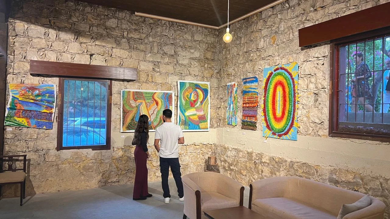Dos visitantes ante obras en la galería